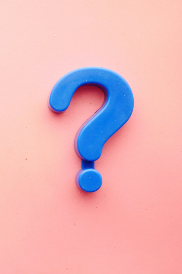 A blue question mark on a pink background